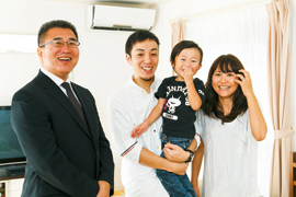 坂口様ご家族と担当の山崎(写真左)